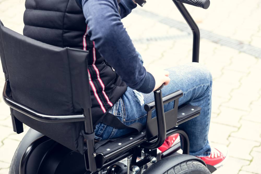 man adjusting proper wheelchair positioning